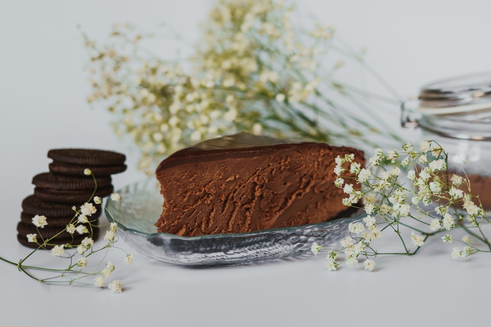 a piece of chocolate cake sitting on top of a glass plate