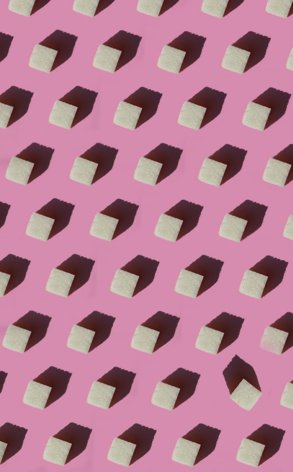 a pink background with a pattern of white blocks