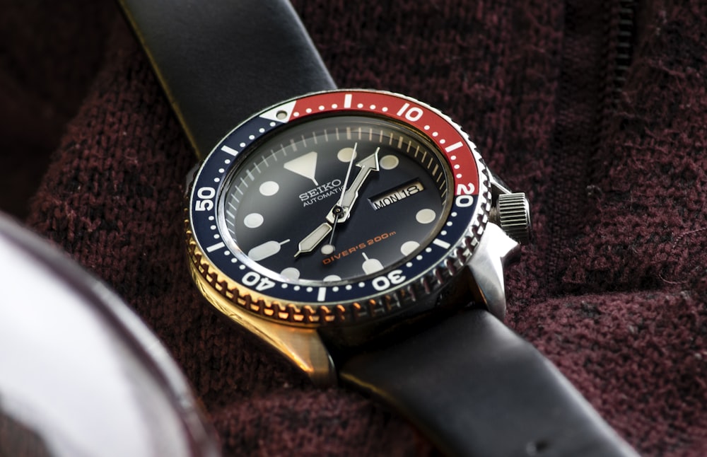 a watch with a red, white and blue bezel