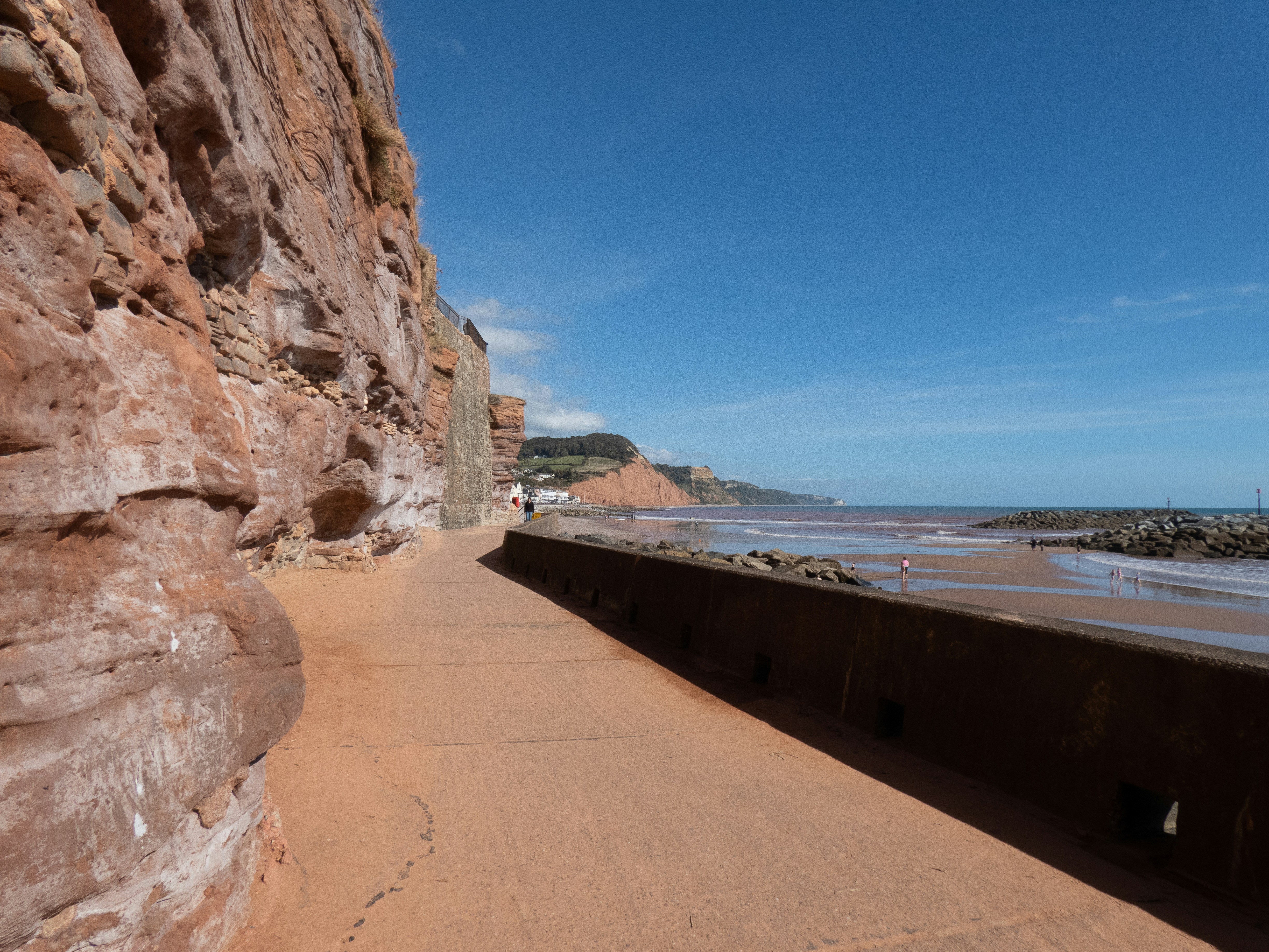 a sandy beach next to a rocky cliff