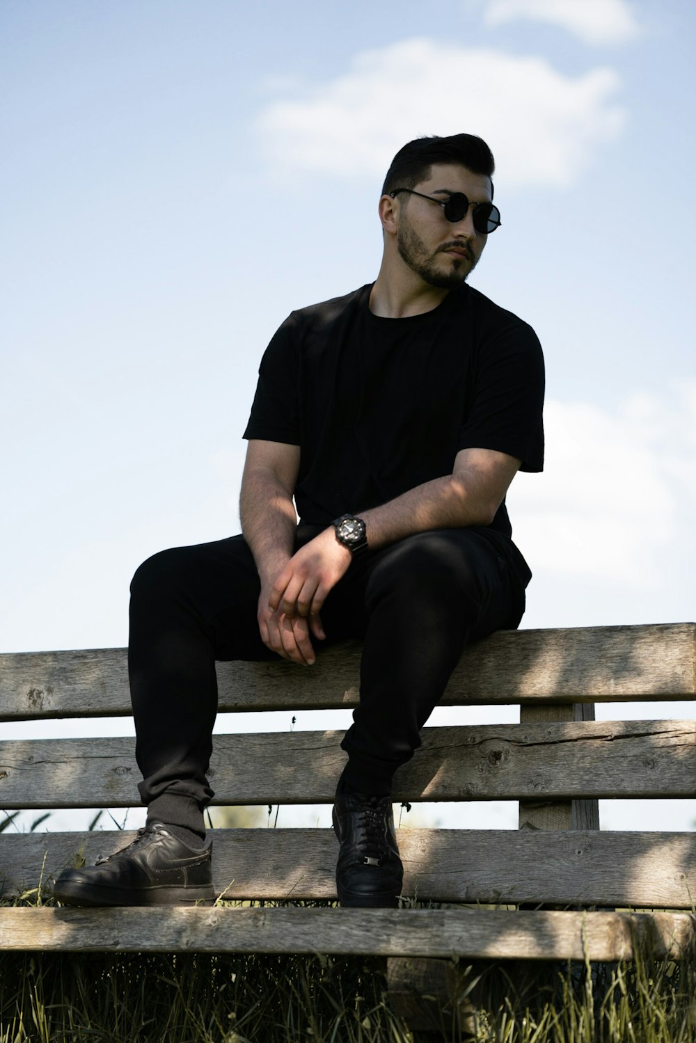 a man sitting on top of a wooden bench