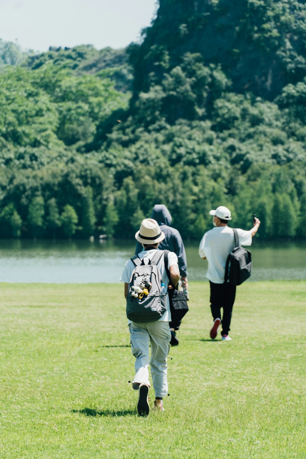 a group of people walking across a lush green field