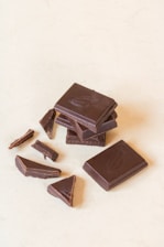 A selection of chocolate bars and truffles arranged on a rustic wooden surface.