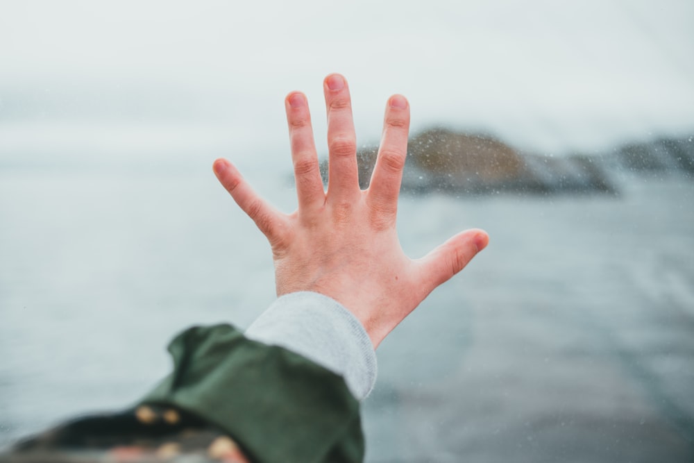 person in black jacket showing left hand