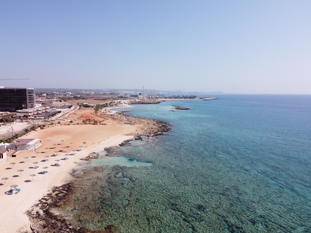 an aerial view of a beach with a hotel in the background