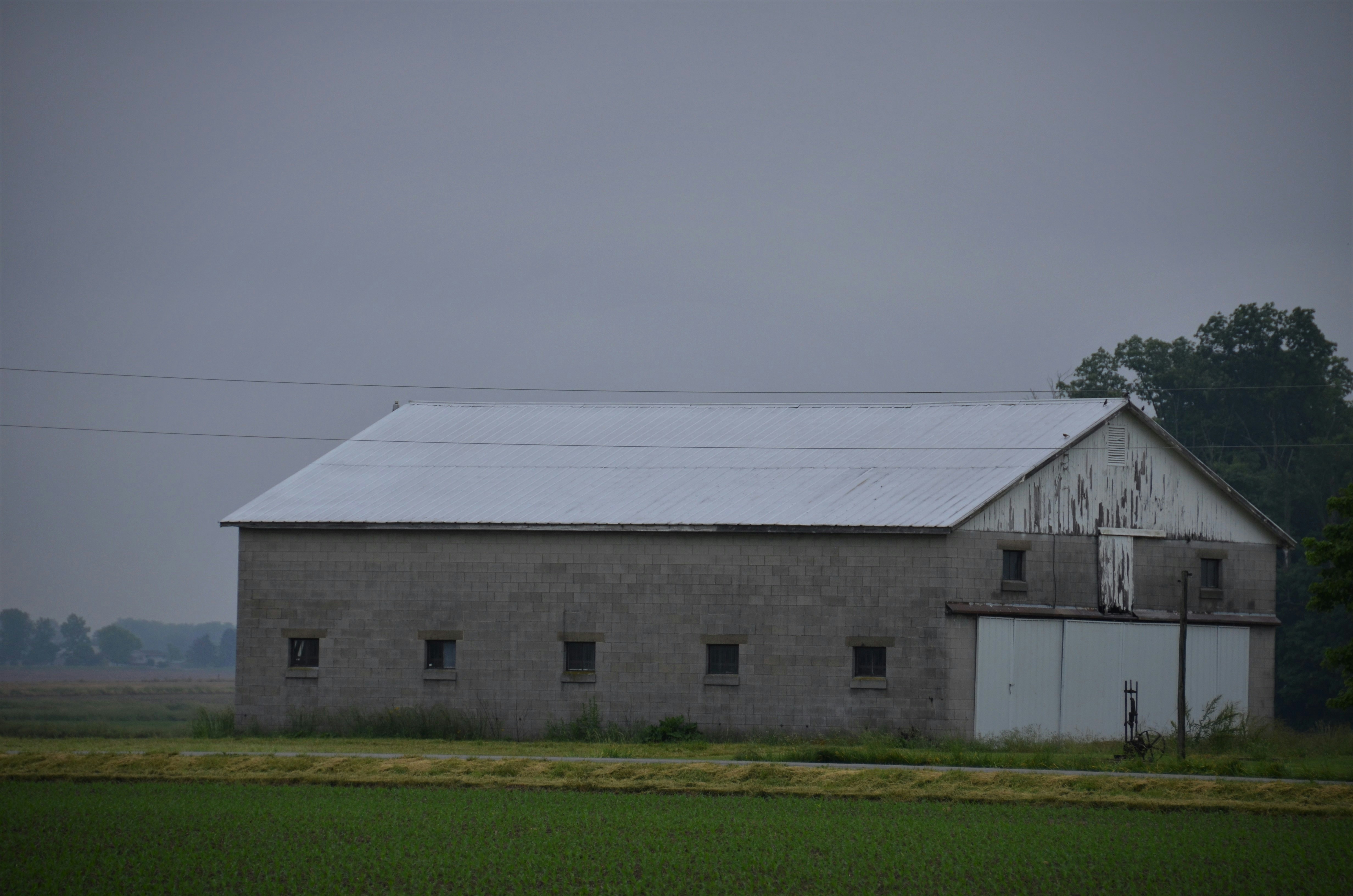 White and gray house near green grass field under gray sky photo – Free ...