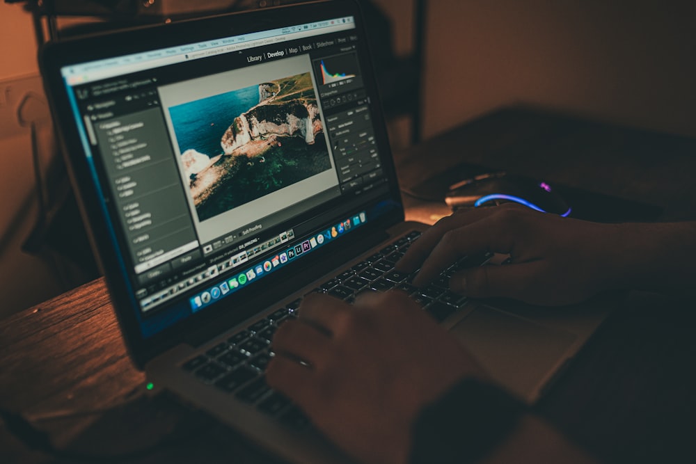 person using macbook pro on table