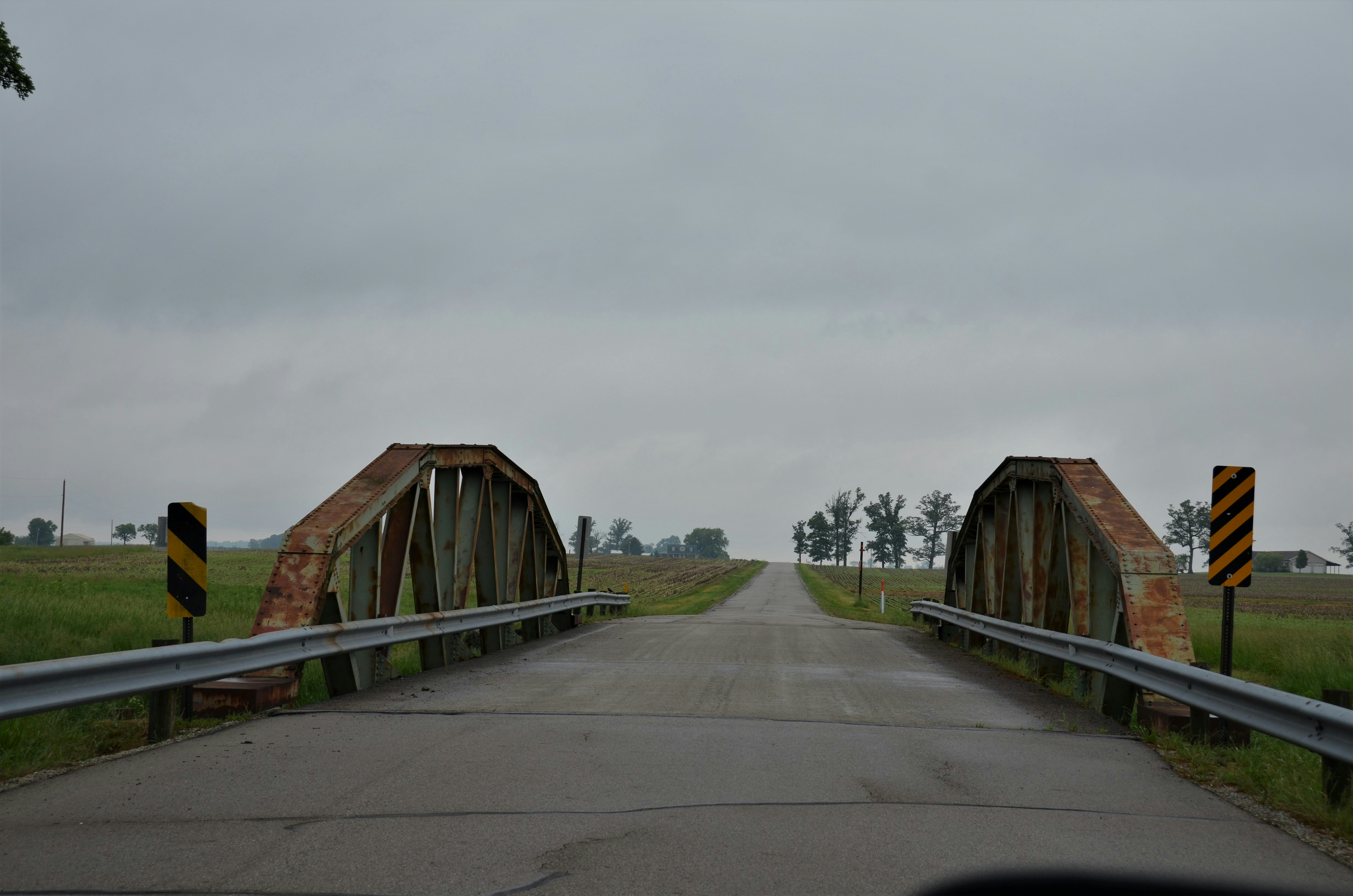 brown wooden house on green grass field under white sky during daytime