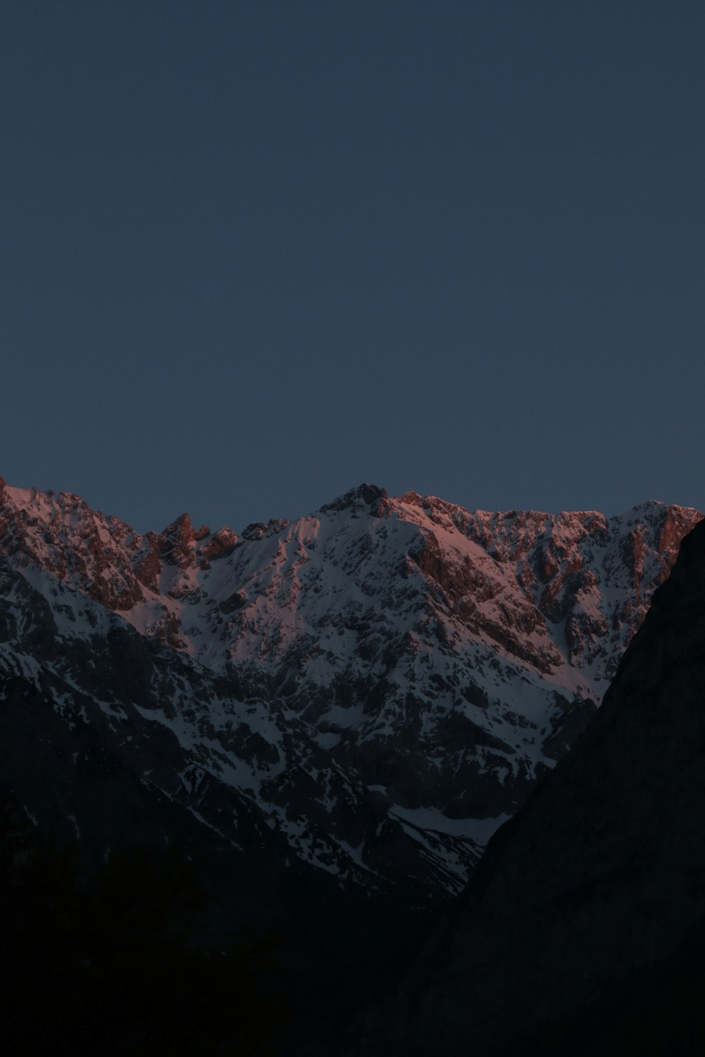 a view of a snowy mountain range at night