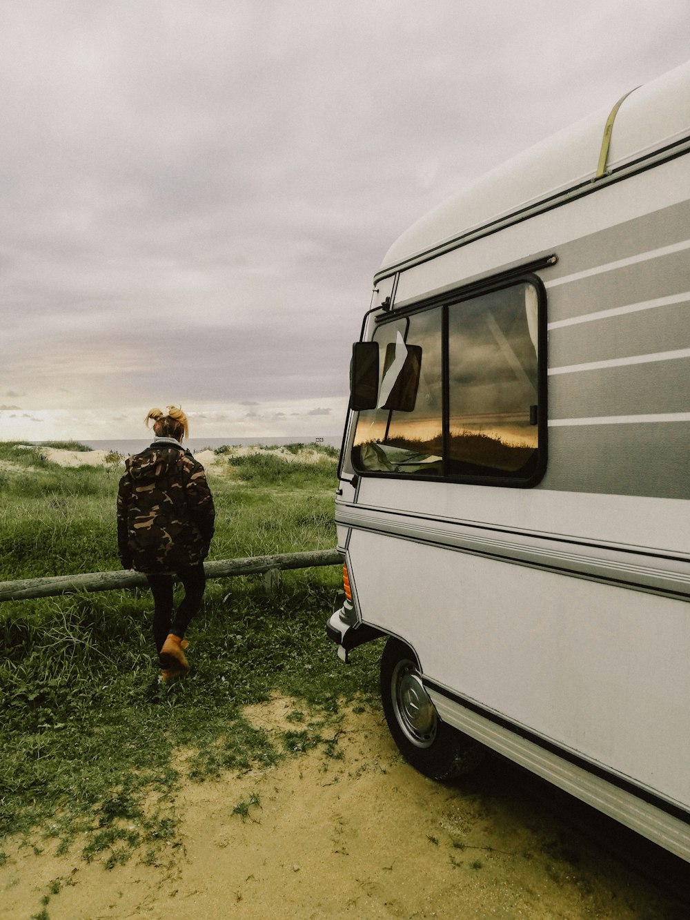 a person standing in front of a parked camper