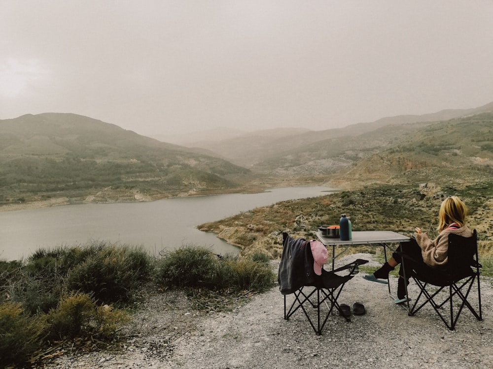 a couple of people sitting at a table on top of a hill