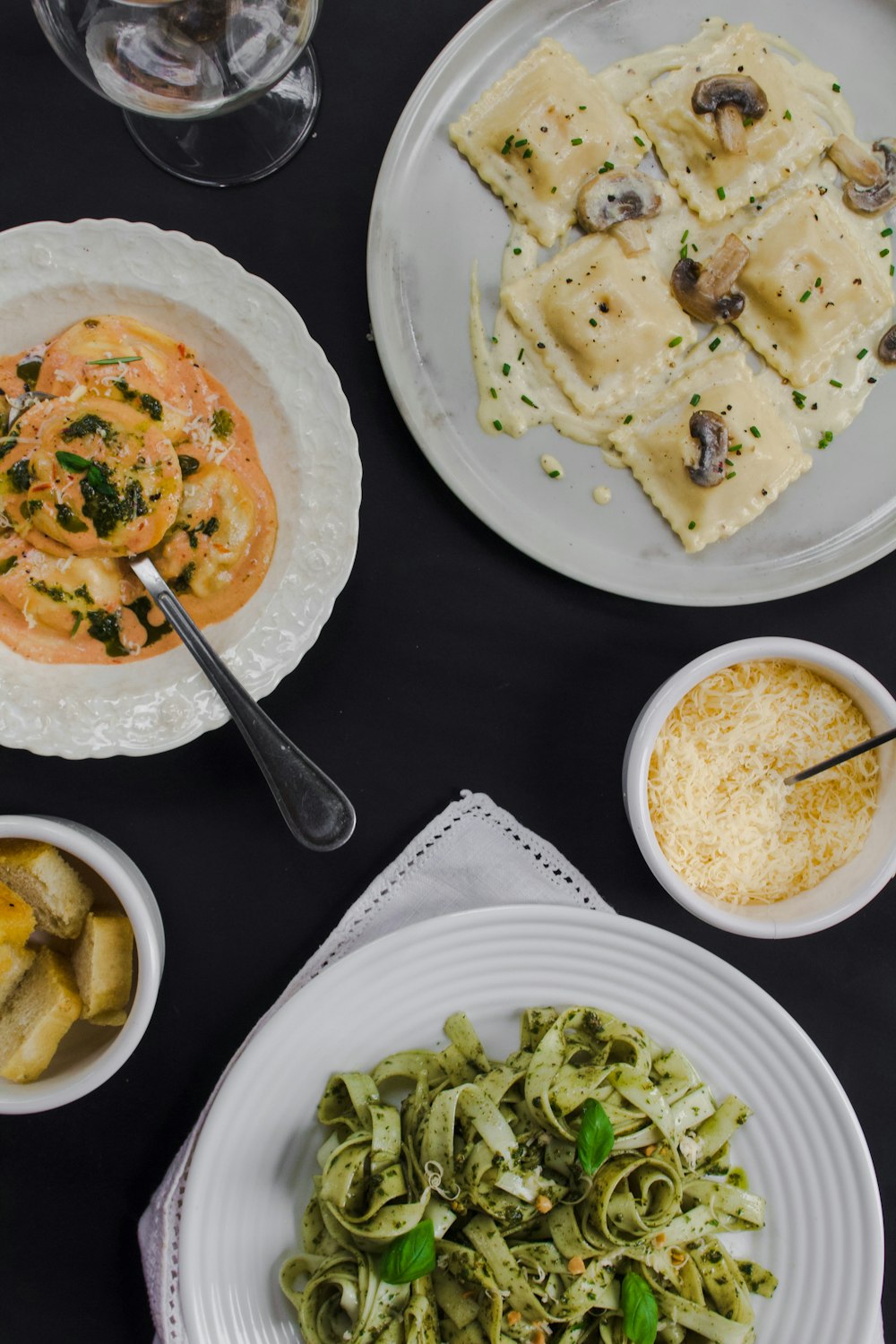 a table topped with plates of food and bowls of pasta