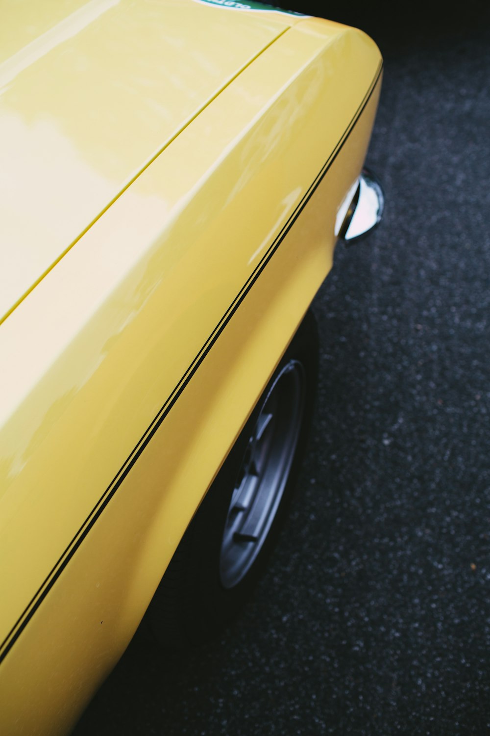 a close up of the side of a yellow car