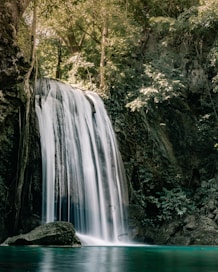 a large waterfall in the middle of a forest
