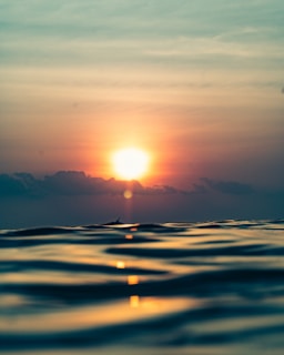 A sunset over a calm sea, symbolizing reflection.