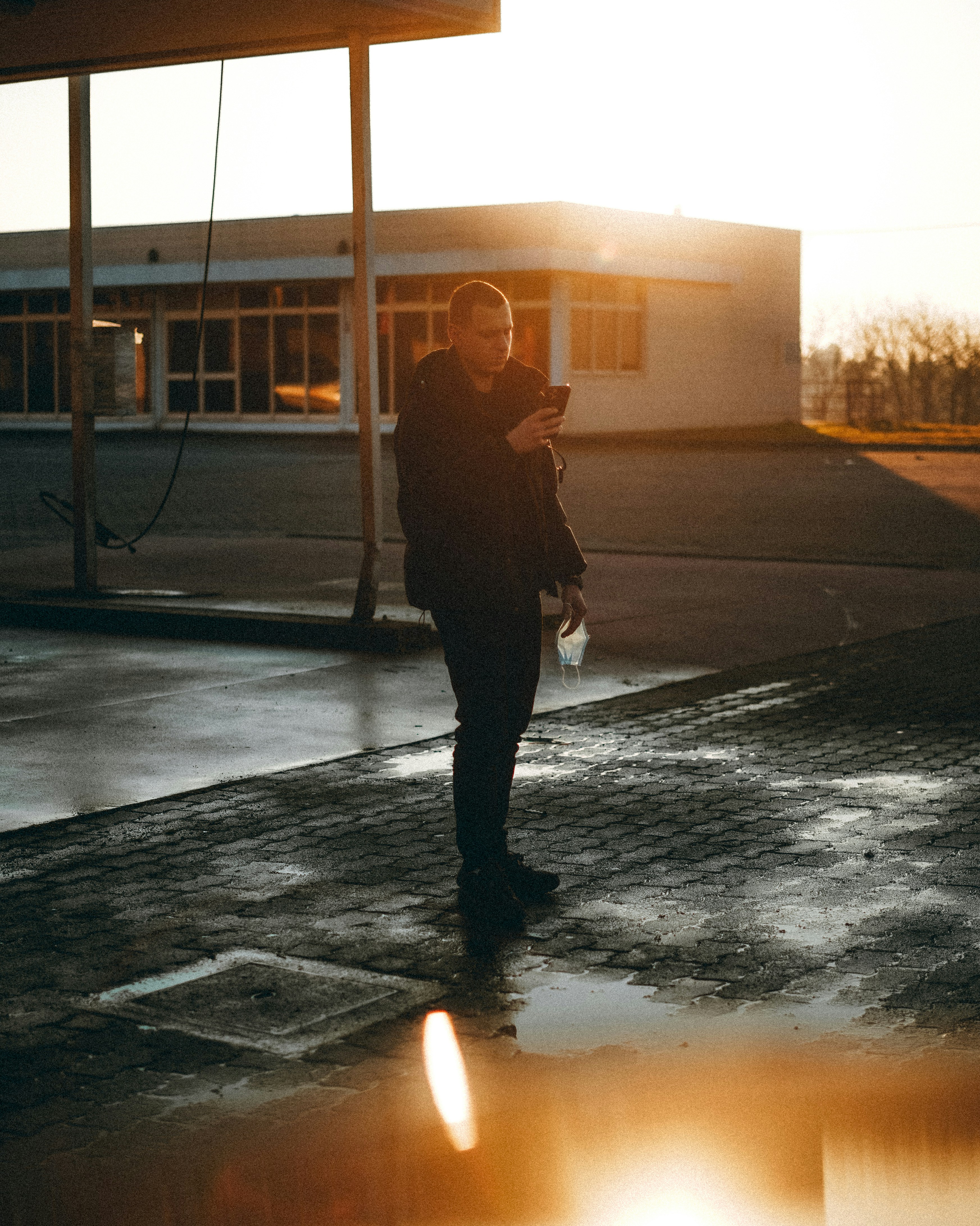 Woman in brown jacket and black pants standing on sidewalk during ...