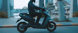 man in black jacket riding on black motor scooter during daytime