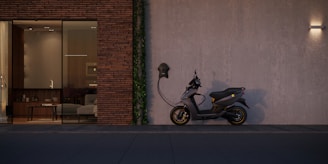 black motorcycle parked beside brown brick wall