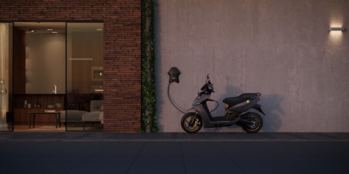black motorcycle parked beside brown brick wall