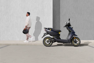 man in white t-shirt and black shorts riding blue motor scooter