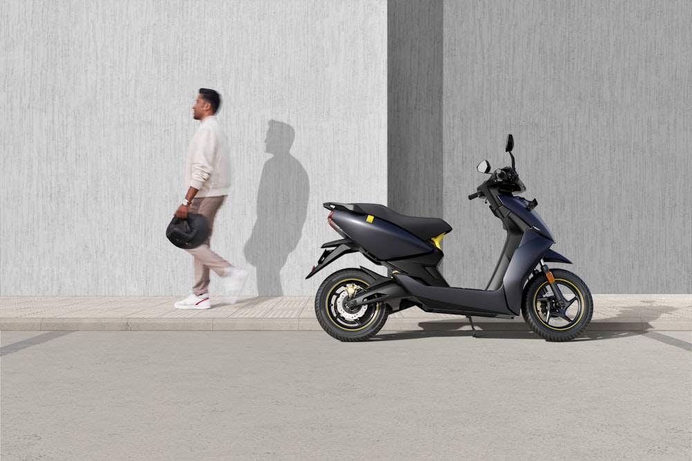 man in white t-shirt and black shorts riding blue motor scooter