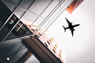 an airplane flying over a building in the sky