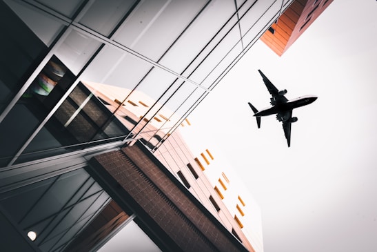an airplane flying over a building in the sky