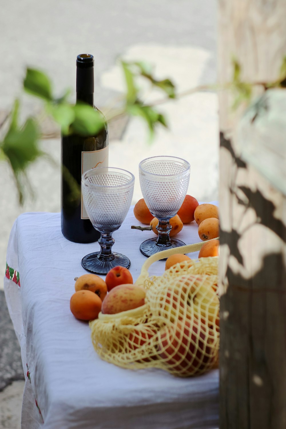 clear wine glass beside orange fruit on white table