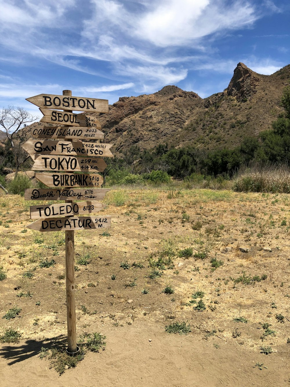 brown wooden signage on brown grass field