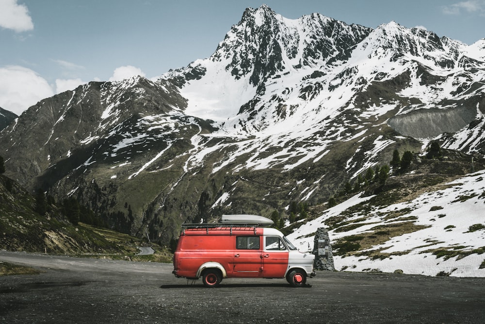 red and white suv on road near snow covered mountain