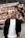 a man with white hair standing in front of a pile of logs