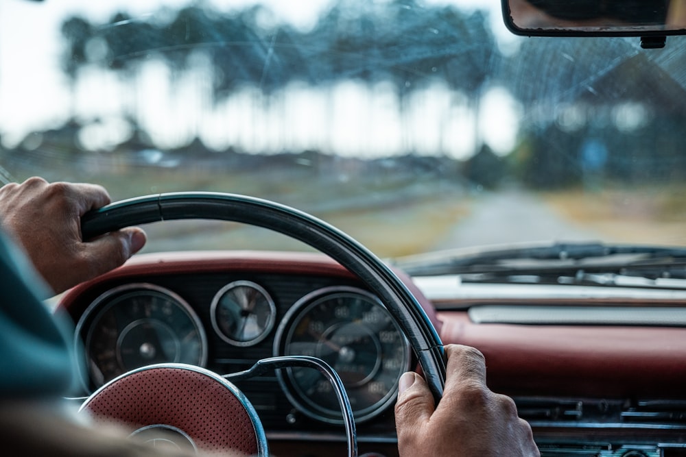 a person driving a car with a steering wheel