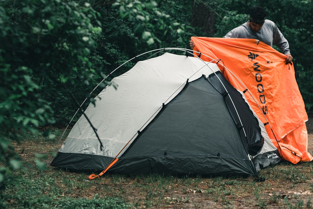 Tenda arancione e grigia sul campo di erba verde durante il giorno