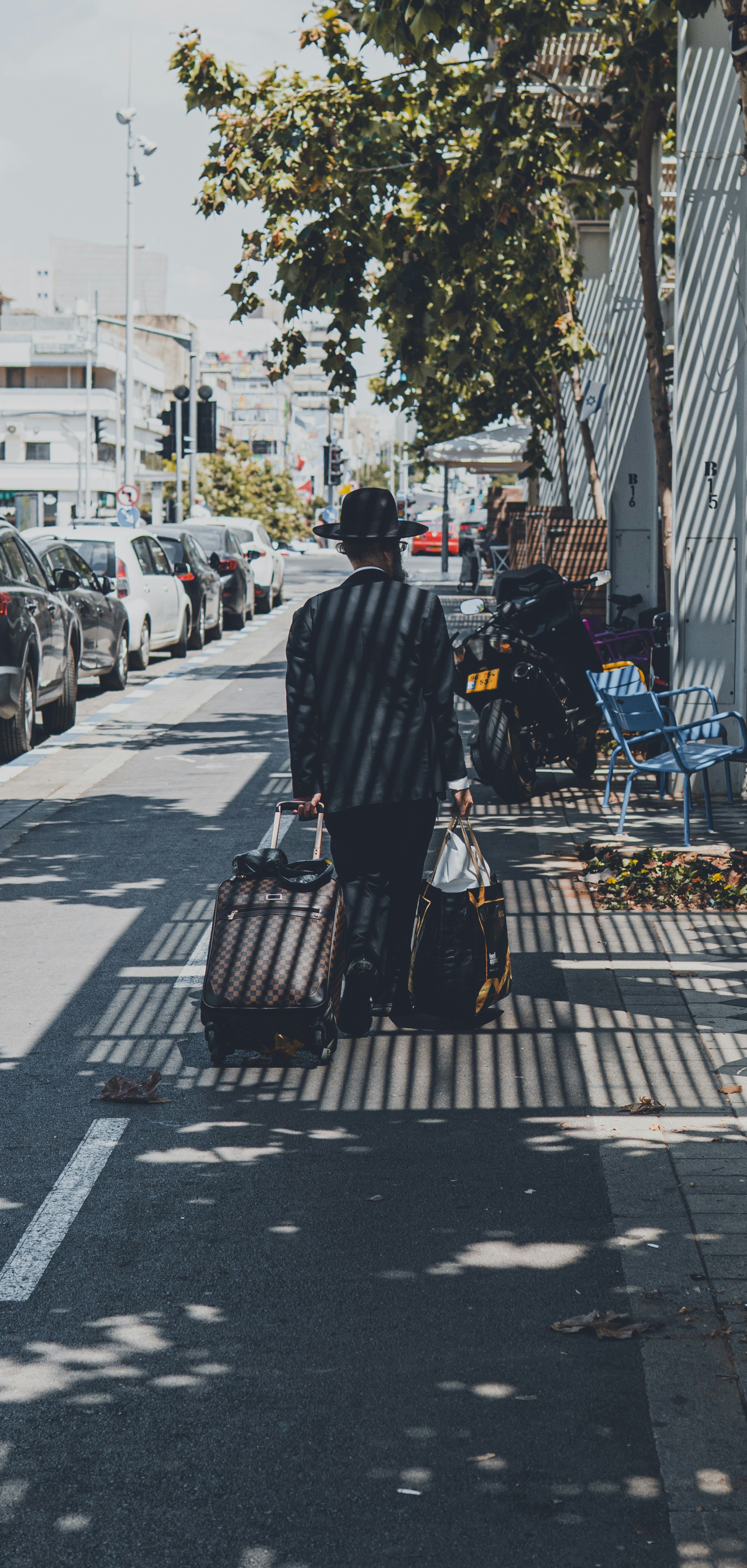 a man walking down the street with his luggage