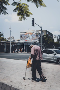 man in black jacket walking on sidewalk during daytime