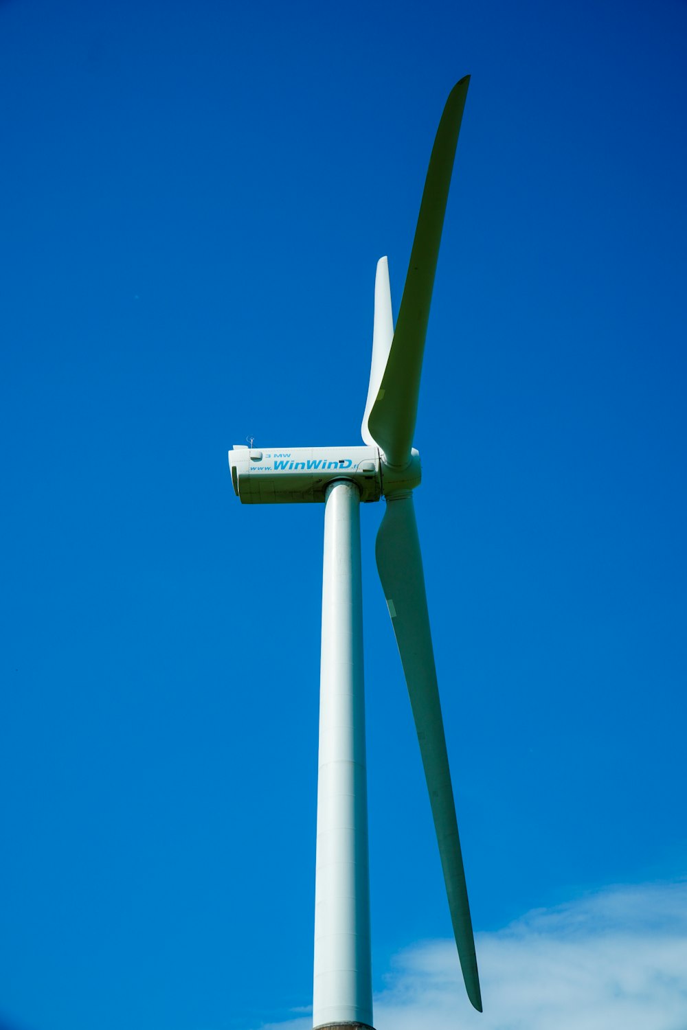 white and green wind turbine under blue sky during daytime