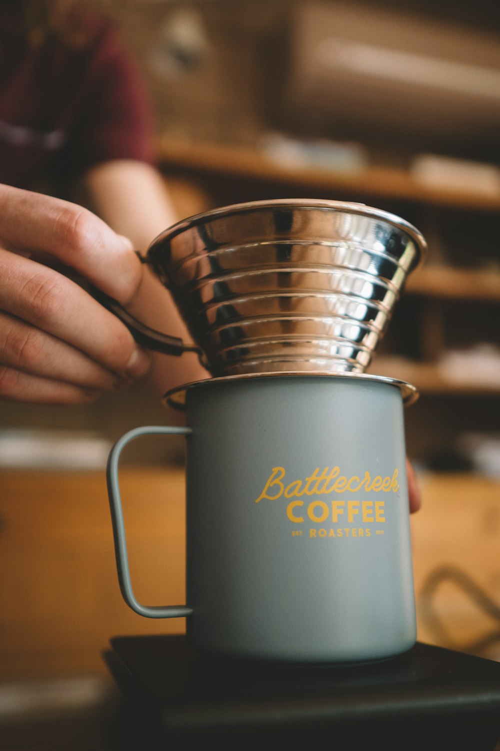 a person is holding a coffee cup on a table