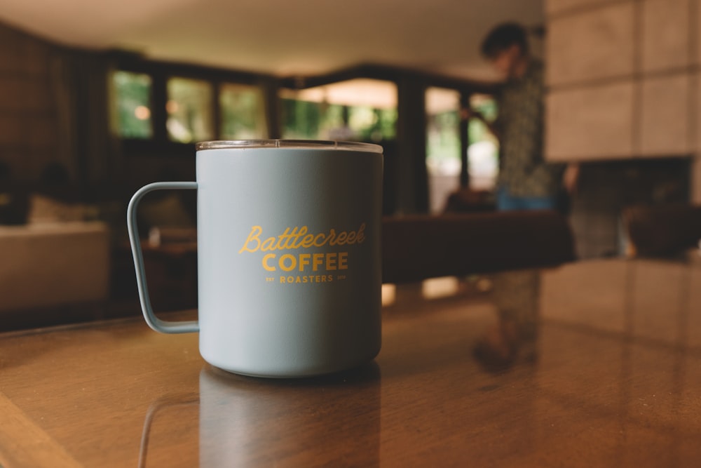 Taza de cerámica blanca sobre mesa de madera marrón