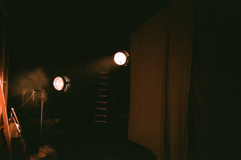 Ein dunkler Raum mit drei Scheinwerfern an der Wand
