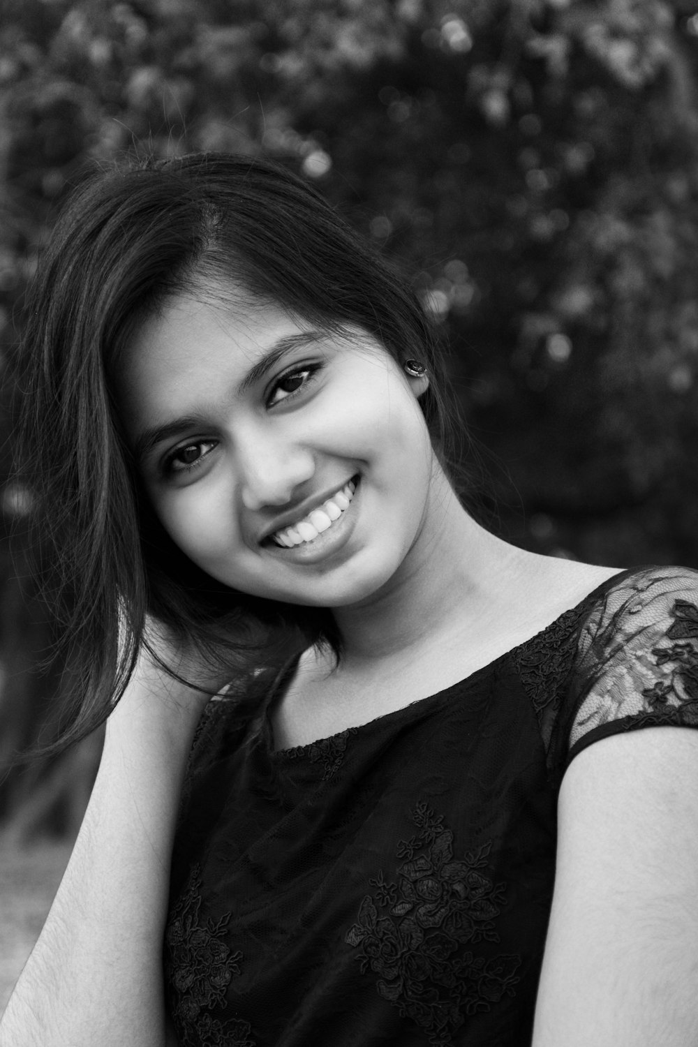 a black and white photo of a woman smiling