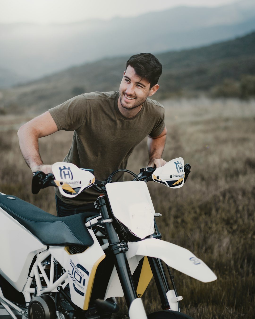 man in brown crew neck t-shirt riding on white and black motorcycle during daytime