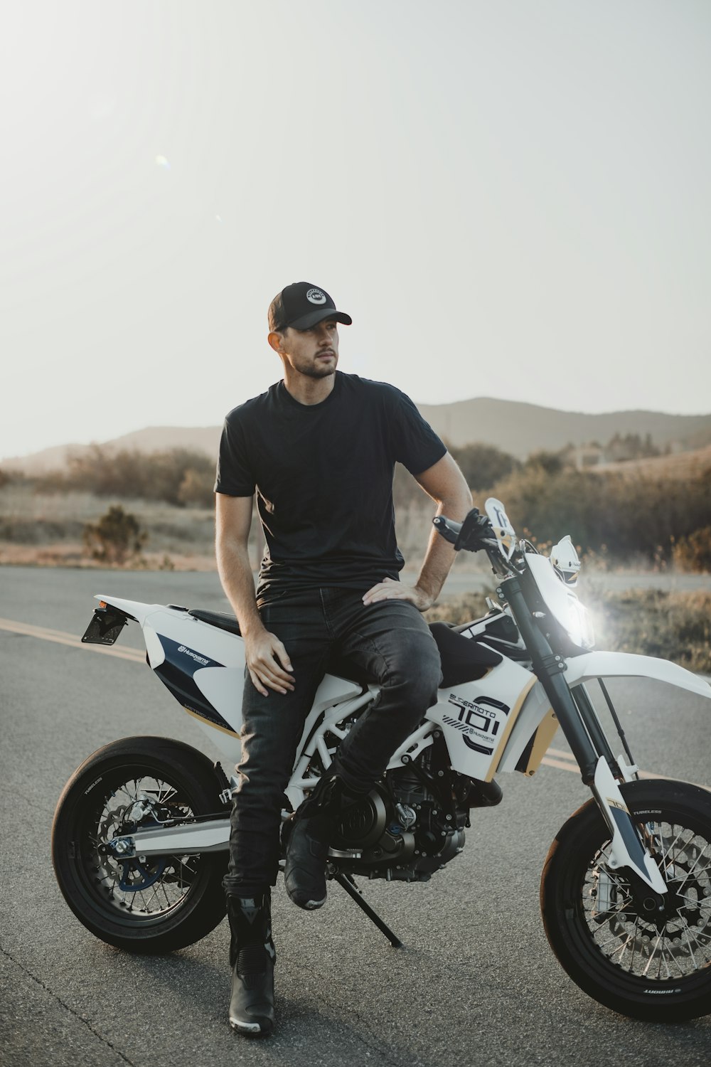 man in black crew neck t-shirt and gray denim jeans sitting on blue and white