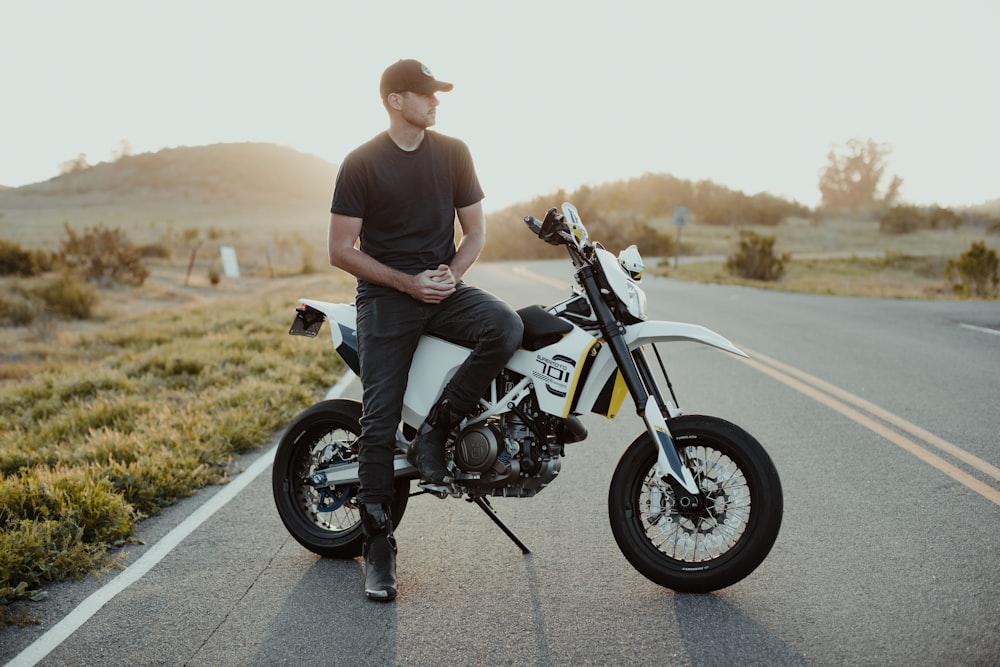 man in black t-shirt riding black motorcycle on road during daytime