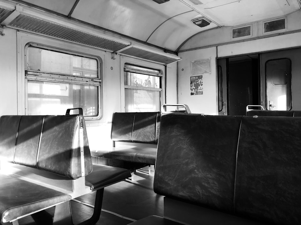 a black and white photo of empty seats on a train