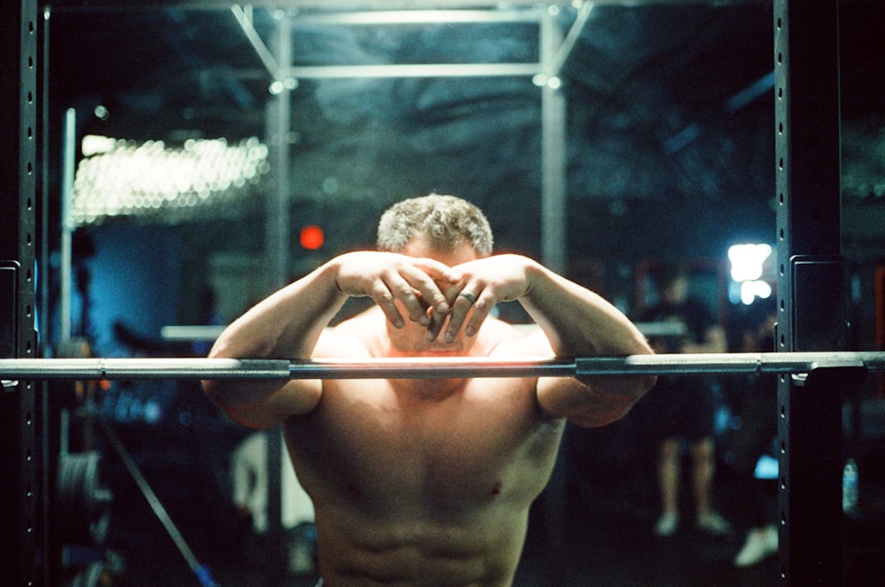 topless man holding on stainless steel bar