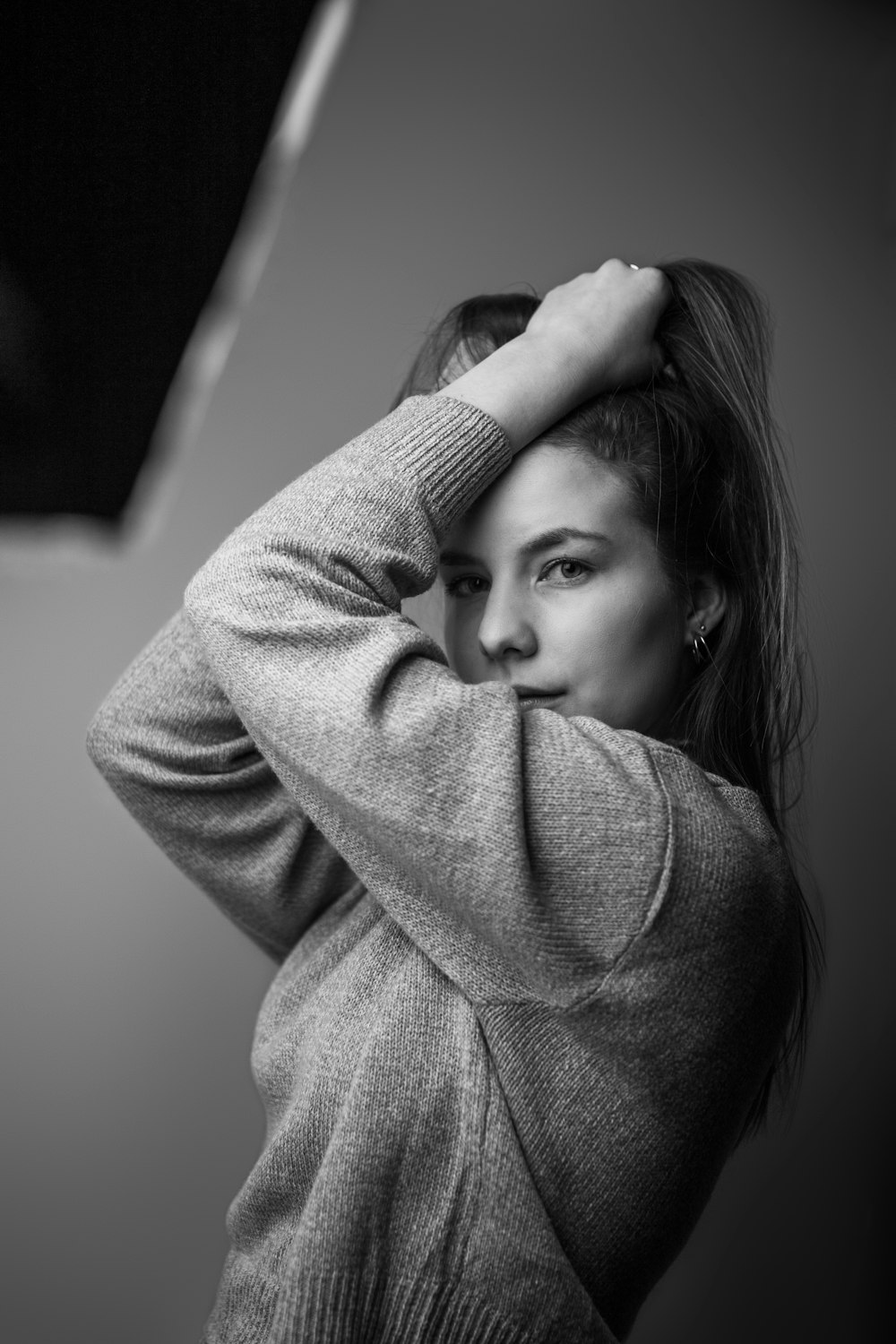 a black and white photo of a woman in a sweater