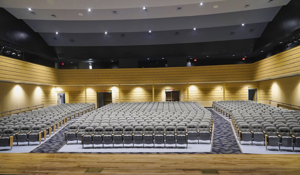 un grande auditorium con file di sedie e un podio