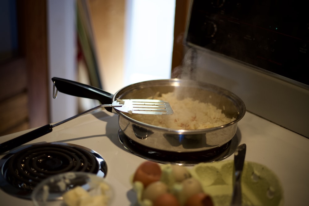 fourchette en acier inoxydable sur poêle à frire noire