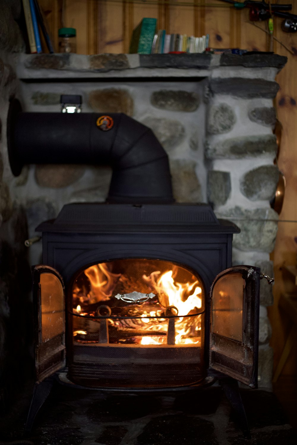 black fireplace with fire in front of white wall