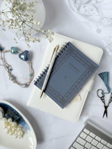 A serene flat lay of a royal blue journal, gold pen, and a vibrant adult coloring book open to a floral design.